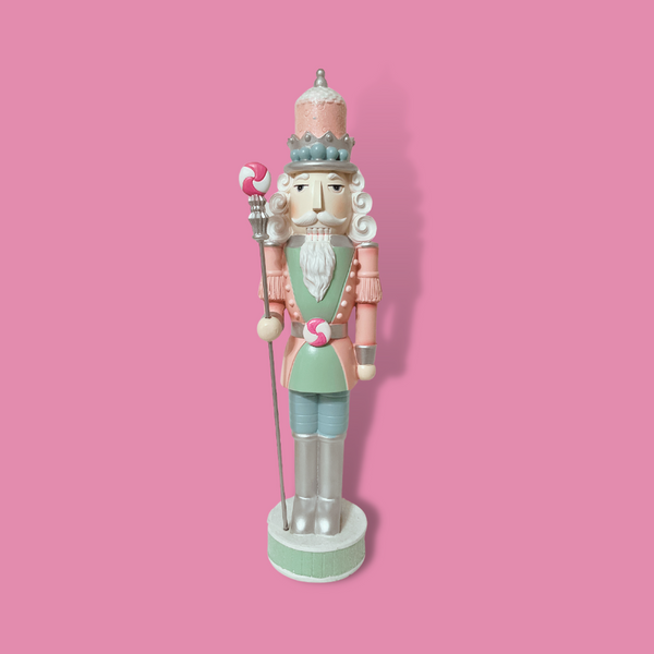 This 18" Resin Nutcracker exudes elegance and charm with its intricate detailing, delicate pastel hues, and distinctive peppermint accents on the belt buckle and staff.