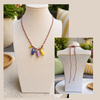 Necklace with colorful fish ceramic beads on a mannequin bust.