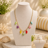 Colorful necklace with sea-themed charms on a mannequin bust with a soft, blurred background.