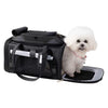 A black pet carrier bag with a white fluffy dog sitting inside on a white background.