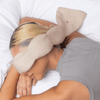 Person lying down with a beige neck pillow on a white background
