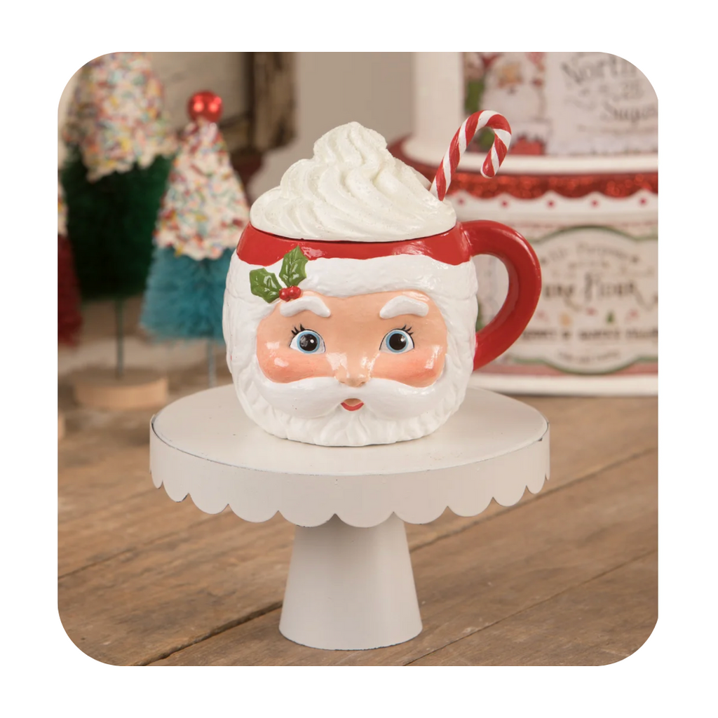 Bethany Lowe's Sweet Tidings Santa Head Mug Container This fabulous perfectly retro Santa container is a wonderful addition to your Christmas decor. Painted in traditional red and green with a holly accents and a sculpted whip cream filled lid with candy cane sprinkles on top, this table piece is sure to be a treasure brought out every year. Cute Christmas Santa Head