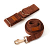 Brown dog leash with gold hardware on a white background