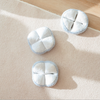 Three white circular objects with gray borders on a beige surface