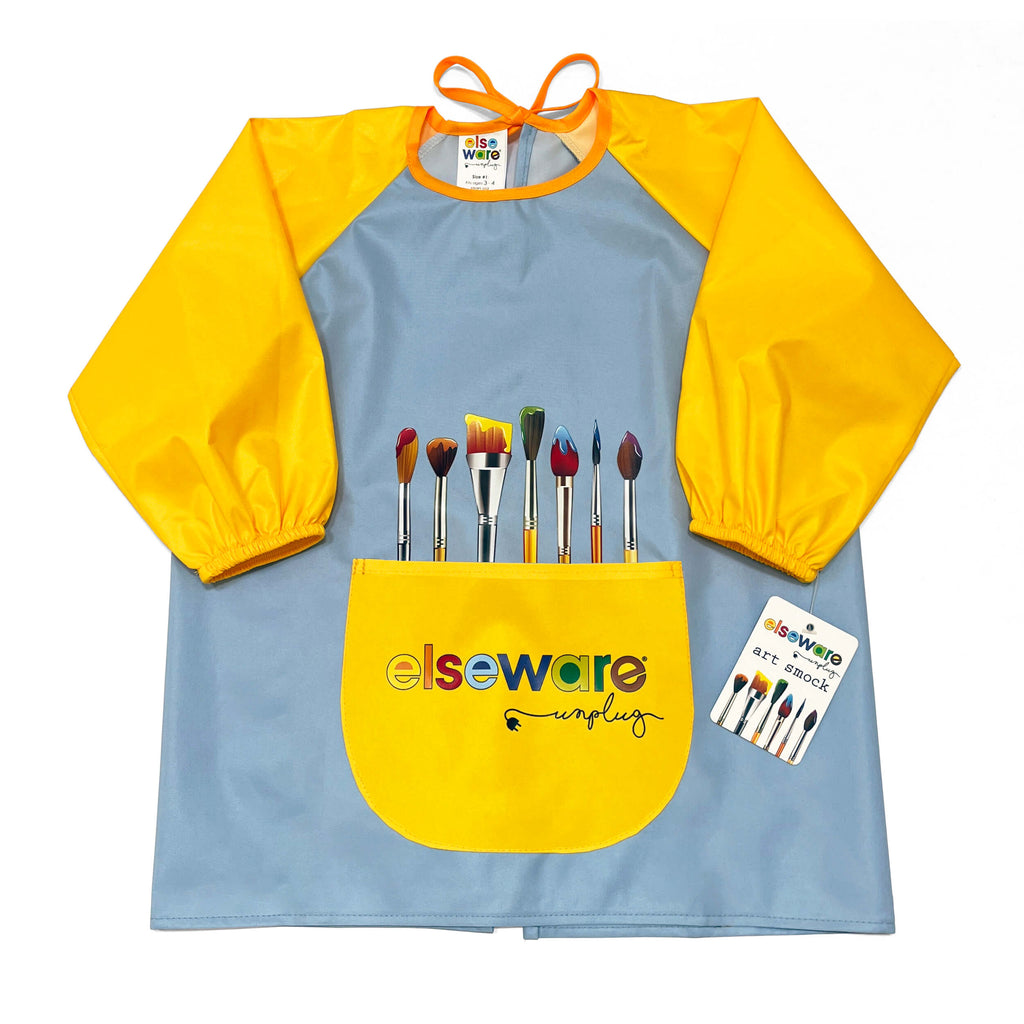 A light blue and yellow Elseware Art Plug paint-splattered apron with a front pocket holding paintbrushes, shown on a white background with a product tag beside it.