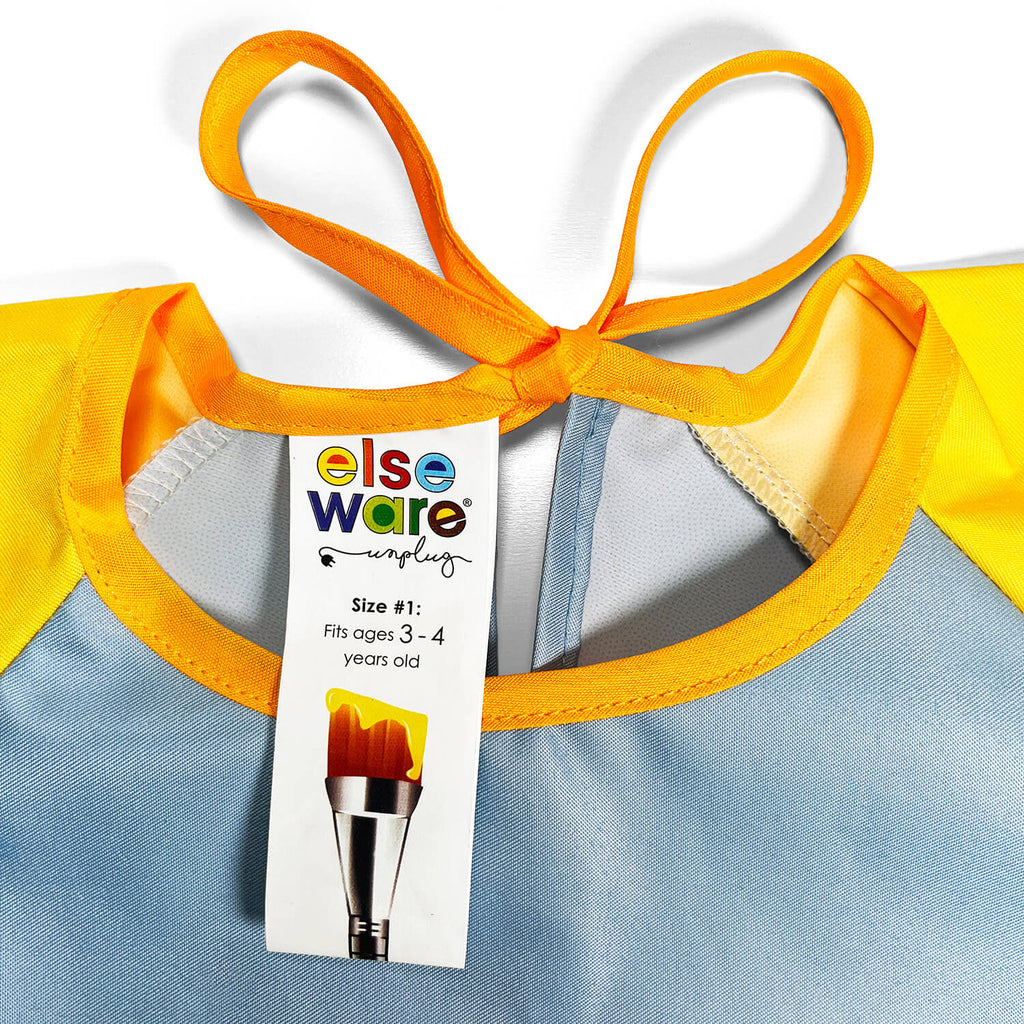 Yellow and blue children's art smock with a tag displaying brand information.