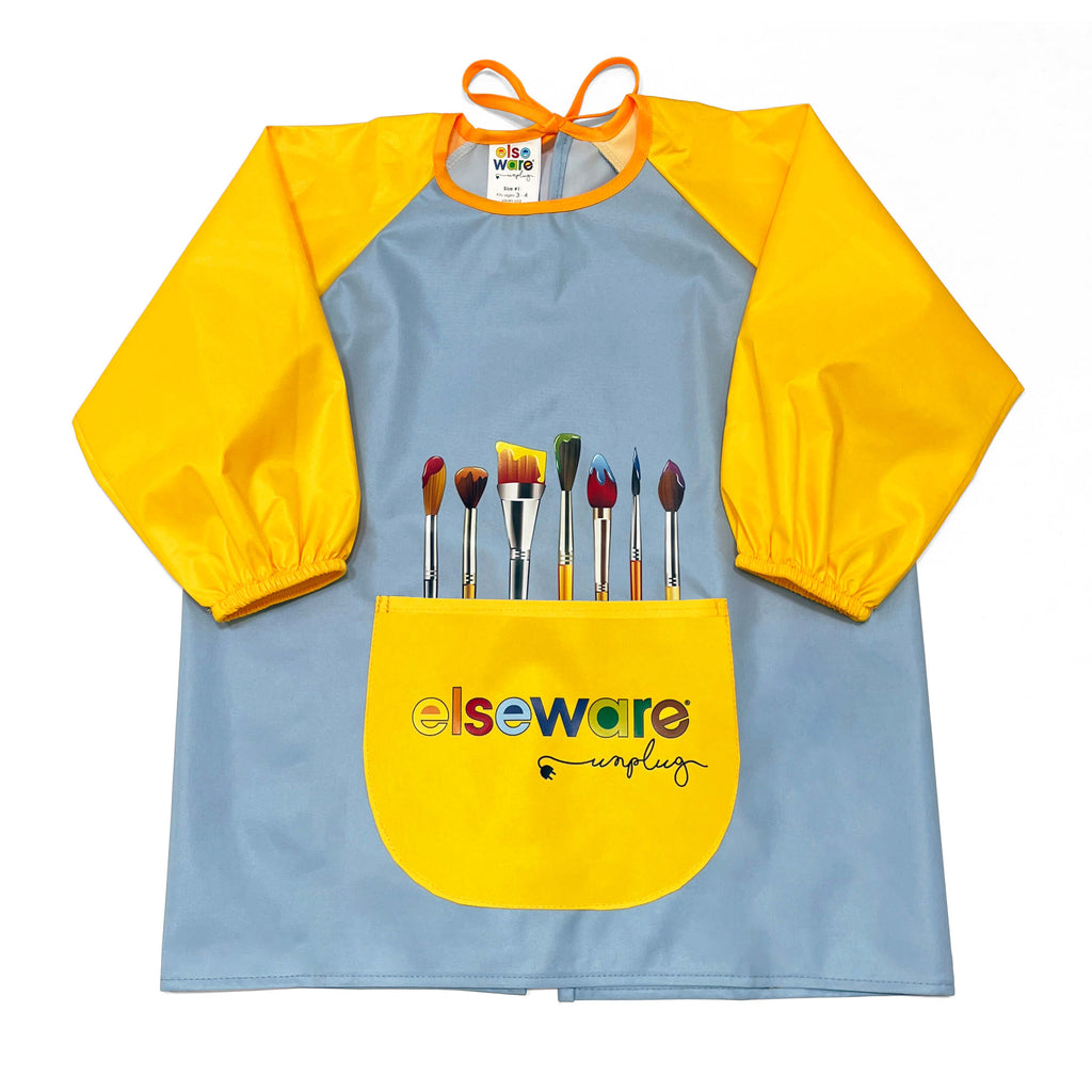 A children's long-sleeve paint smock with a light blue body, bright yellow sleeves and front pocket, and printed paintbrushes above the pocket. The front pocket has the 'elseware unplugged' logo.
