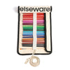 An Elseware fabric art supply roll-up organizer filled with colored pencils, markers, and paintbrushes, shown on a clean white background.