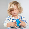 Child playing with a blue object against a plain background