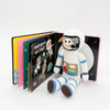 Crocheted astronaut toy with a children's book on a white background