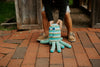 Child holding a striped toy octopus on a brick path