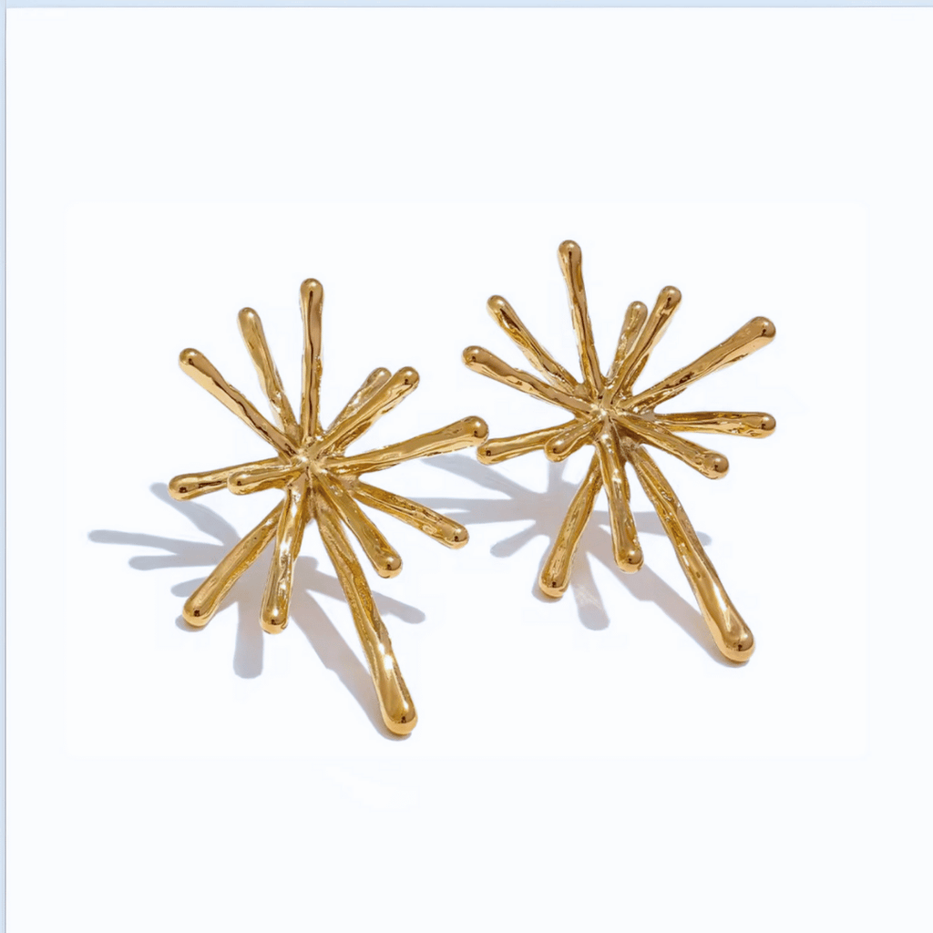 Gold starburst earrings on a white background