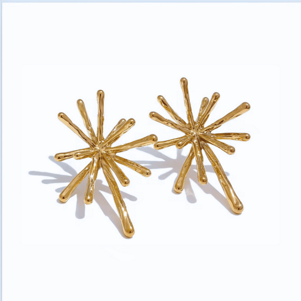 Gold starburst earrings on a white background