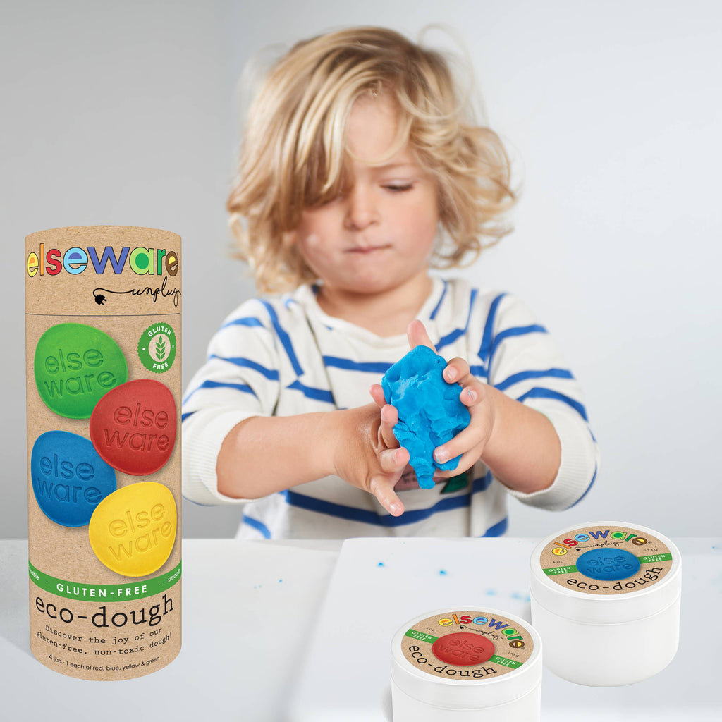 Child playing with eco-dough next to packaging and containers on a white background