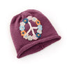 Knitted hat with a peace sign made of flowers on a white background
