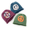 Three knit hats with peace symbol designs on a white background