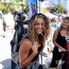 Woman with a dog in a backpack at an outdoor event