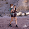 Woman hiking with a dog in a backpack in a desert landscape
