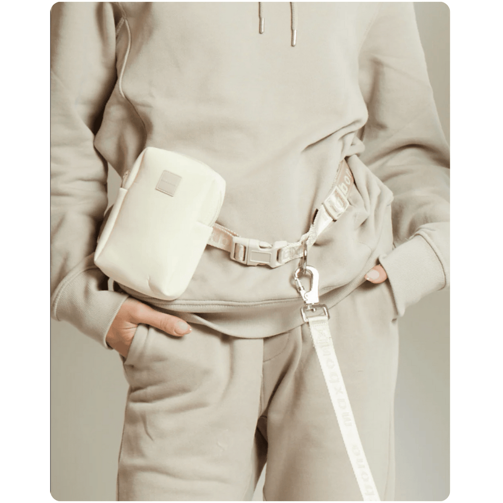 Person wearing a beige outfit with a matching waist bag on a white background