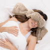 Woman wearing fluffy eye masks and ear covers in bed