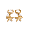 Gold hoop earrings with starfish and pearl charms on a white background