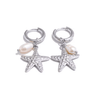 Pair of silver hoop earrings with starfish and pearl charms on a white background