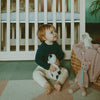 Child sitting on the floor with toys in a nursery