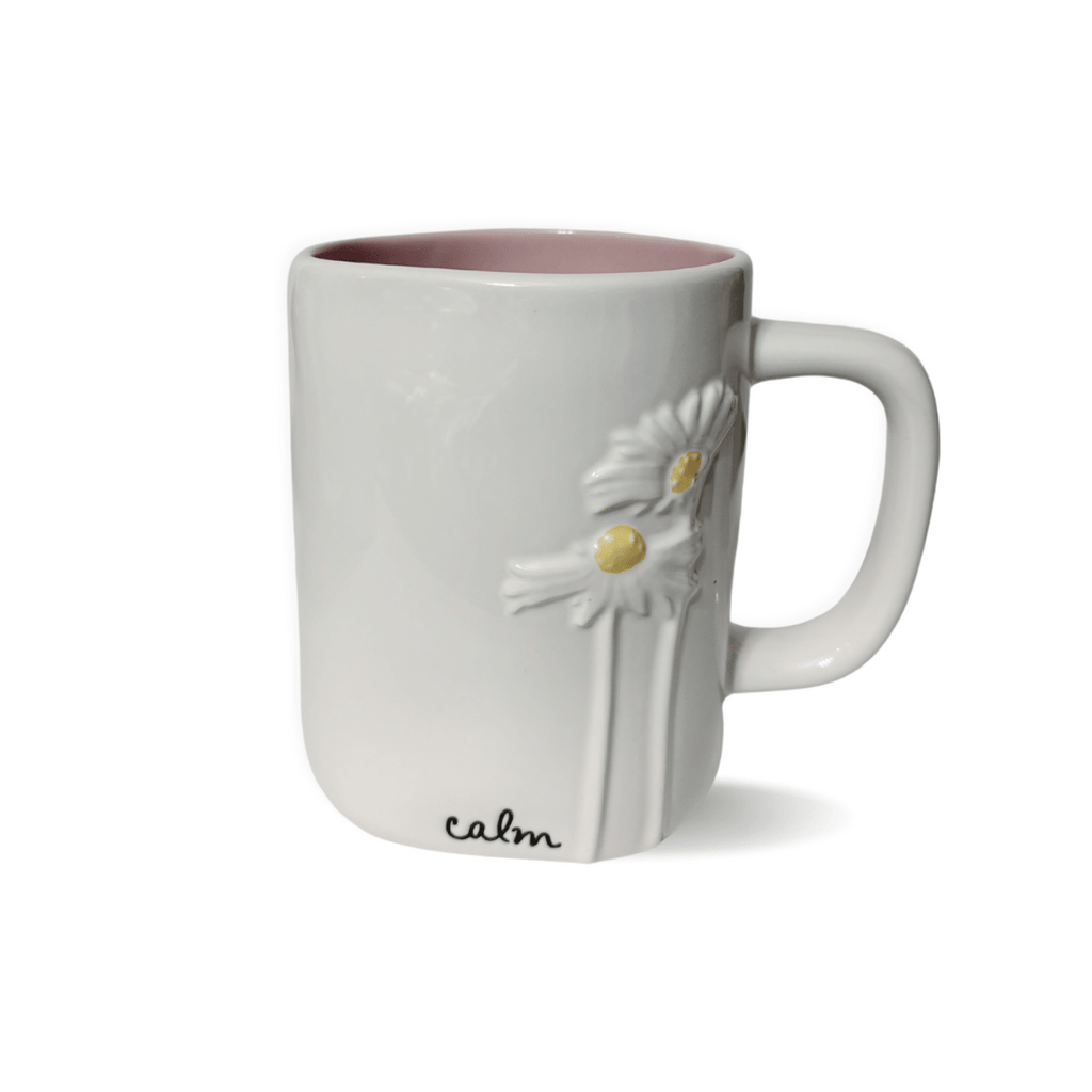 Experience the beauty and craftsmanship of this white ceramic mug, adorned with Rae Dunn's elegant cursive "Calm" and delicate raised daisies. Let this mug bring a sense of tranquility and grace to your daily coffee routine.