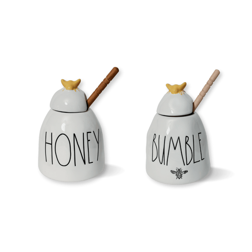 Expertly-crafted honey pots in 2 charming designs. Rae Dunn x Magenta's artisan stoneware features a delightful yellow bee top and a wooden honey comb spoon. Choose from two styles: "Honey" or "Bumble". Rae Dunn Honey Rae Dunn Bumble Rae Dunn Honey pot 