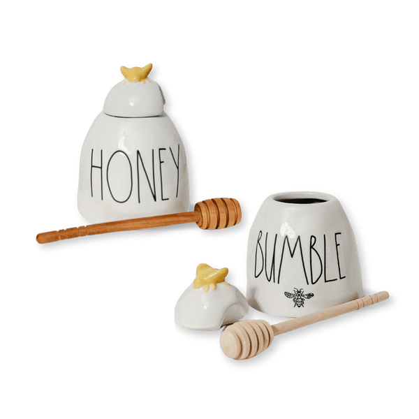 Expertly-crafted honey pots in 2 charming designs. Rae Dunn x Magenta's artisan stoneware features a delightful yellow bee top and a wooden honey comb spoon. Choose from two styles: "Honey" or "Bumble". Rae Dunn Honey Rae Dunn Bumble Rae Dunn Honey pot