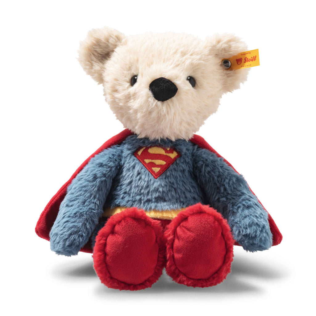 Steiff Plush bear toy dressed as Superman with a red cape and blue suit on a white background