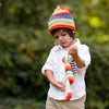 Child wearing a colorful knit hat and scarf outdoors