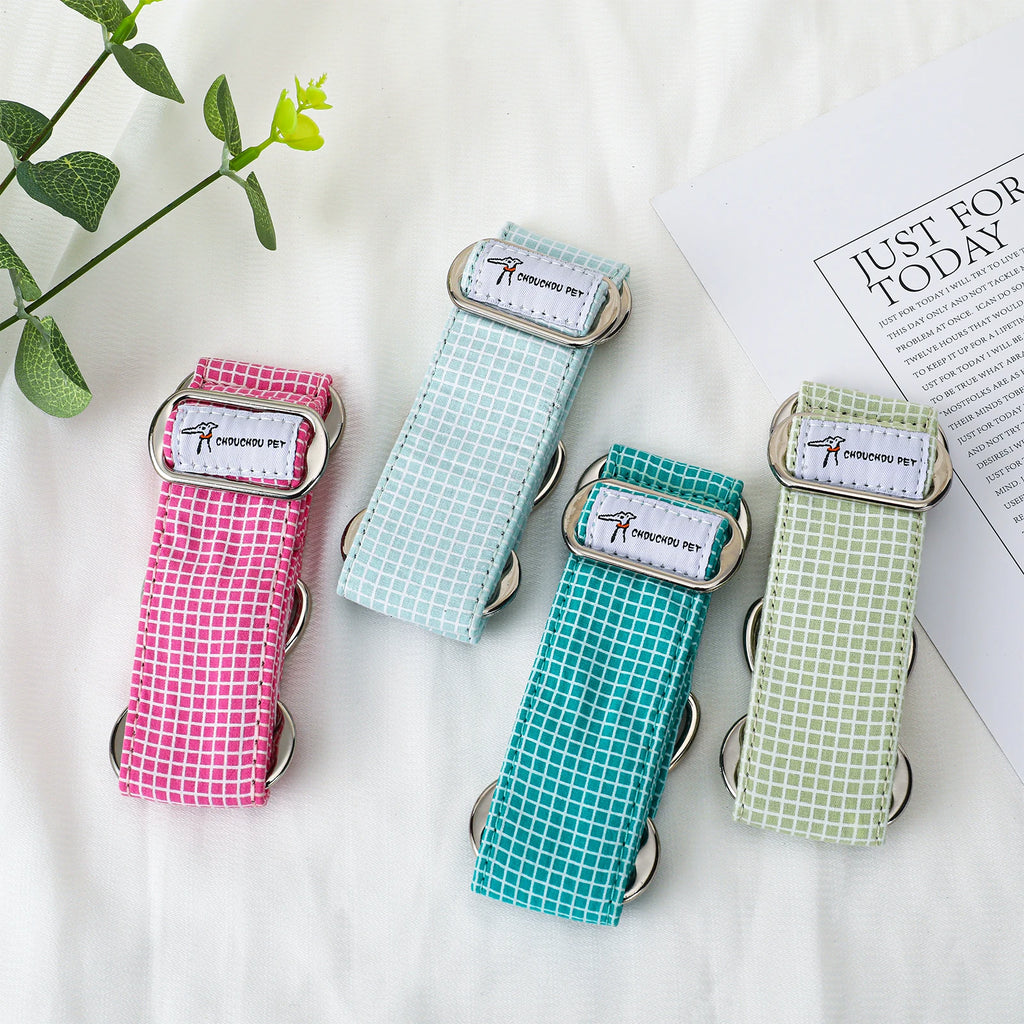 Four dog collars. The straps are pink, pale blue, teal, and light green, each with a small grid pattern.