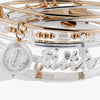 Stack of gold and silver bracelets with 'Faith' on a white background